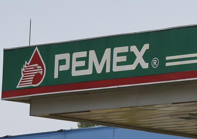 (FILES) Picture of the logo of Mexico's state oil company Pemex, taken at gas station in Mexico City on April 20, 2020 during the coronavirus COVID-19 pandemic. Mexico's state oil company Pemex reported a smaller loss in the third quarter of 2025 compared to the same period in 2024, citing lower sales costs and a foreign exchange gain. The company continues to struggle with heavy debt and declining hydrocarbon production. (Photo by Alfredo ESTRELLA / AFP)