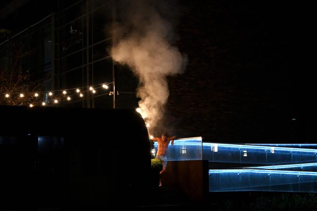 A man cools off outside as he visits the sauna in a harbour bath in Copenhagen on October 27, 2025. (Photo by Sergei GAPON / AFP)