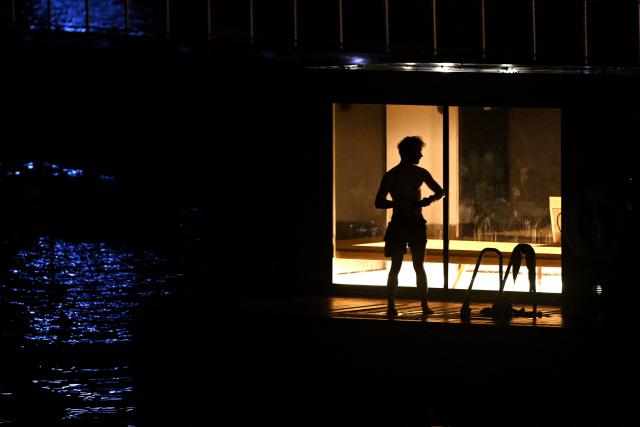 A man cools off outside as he visits the sauna in a harbour bath in Copenhagen on October 27, 2025. (Photo by Sergei GAPON / AFP)