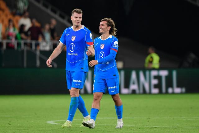 Atletico Madrid's French forward #07 Antoine Griezmann (R) and Atletico Madrid's Norwegian forward #09 Alexander Sorloth smile at the end of the Spanish league football match between Real Betis and Club Atletico de Madrid at the Cartuja Stadium in Seville on October 27, 2025. Atletico Madrid won 0-2. (Photo by CRISTINA QUICLER / AFP)