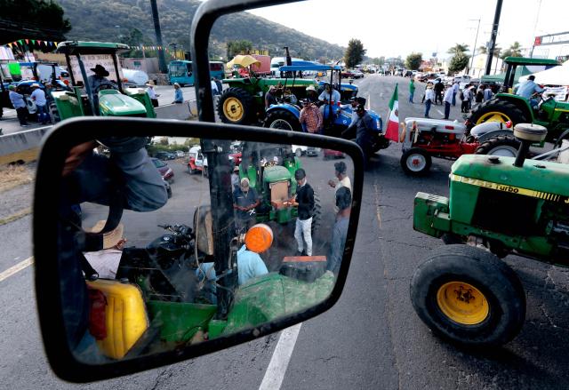 Farmers are reflected on a mirror as they block the highway to Nogales to protest the price of corn and against the federal government in Zapopan, Jalisco state, Mexico on October 27, 2025. (Photo by ULISES RUIZ / AFP)