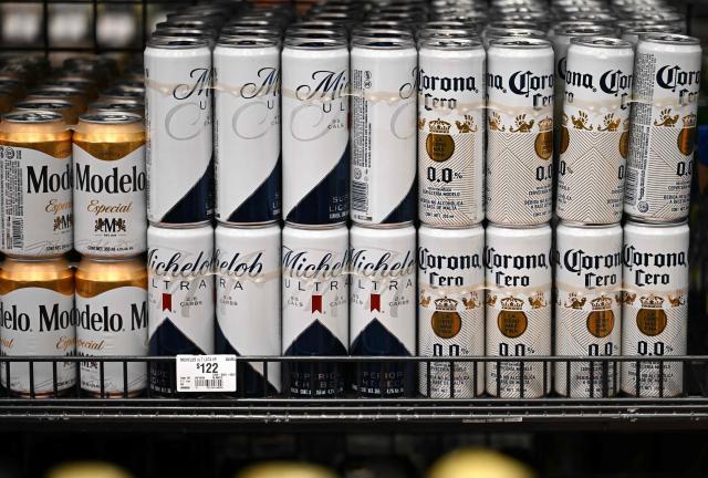 This view shows cans of the Mexican beer Modelo (L), Corona and Argentine gluten-free beer Michele Ultra on display for sale at a Walmart store in Mexico City on October 27, 2025. (Photo by Yuri CORTEZ / AFP)