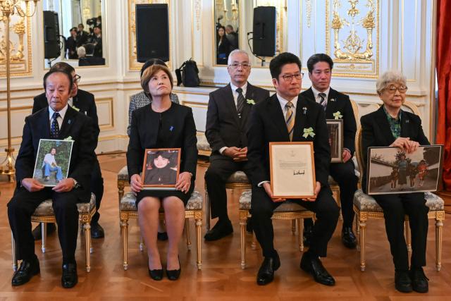 Family members of Japanese citizens abducted by North Korea hold portraits before a meeting with US President Donald Trump and Japan's Prime Minister Sanae Takaichi at the Akasaka State Guest House in Tokyo on October 28, 2025. (Photo by ANDREW CABALLERO-REYNOLDS / AFP)