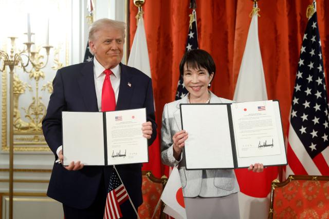 US President Donald Trump and Japan's Prime Minister Sanae Takaichi pose during a signing ceremony for a document on the implementation of the US-Japan trade deal at the Akasaka State Guest House in Tokyo on October 28, 2025. (Photo by Kiyoshi Ota / POOL / AFP)