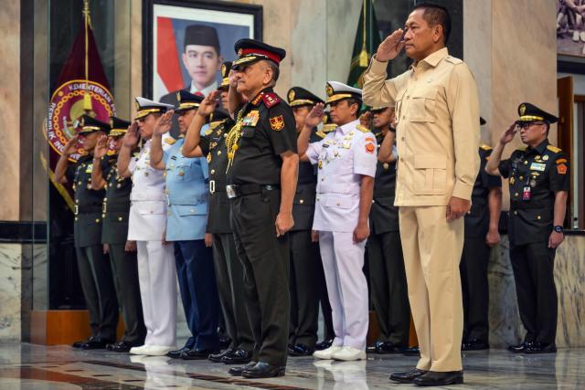 India's Chief of Defence Staff General Anil Chauhan (C) salutes while accompanied by Indonesia's Deputy Minister of Defence Donny Ermawan Taufanto (front R) during a welcoming ceremony at the Ministry of Defence in Jakarta on October 28, 2025. (Photo by BAY ISMOYO / AFP)