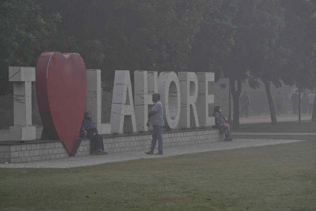 People visit a park amid dense smog in Lahore on October 28, 2025. (Photo by Arif ALI / AFP)