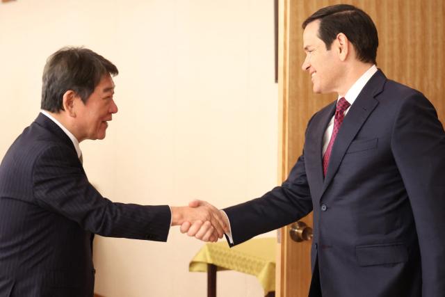 US Secretary of State Marco Rubio (R) shakes hands with his Japanese counterpart Toshimitsu Motegi (R) prior to their talks at the Foreign Ministry in Tokyo on October 28, 2025. (Photo by YOSHIKAZU TSUNO / POOL / AFP)