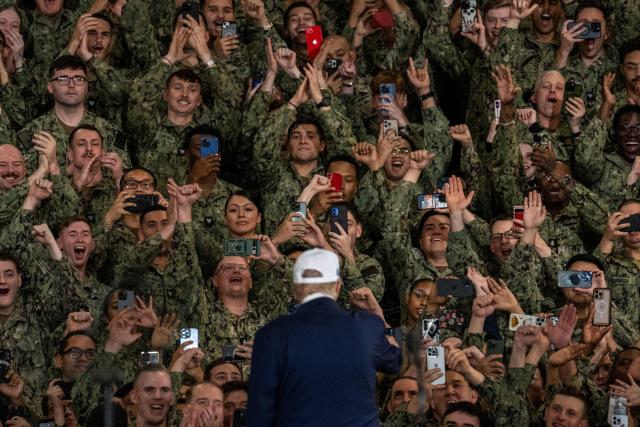 US Navy personnel use their mobile phones to take photos of US President Donald Trump as he arrives to deliver a speech on board the US Navy's USS George Washington aircraft carrier at the US naval base in Yokosuka on October 28, 2025. (Photo by Philip FONG / AFP)