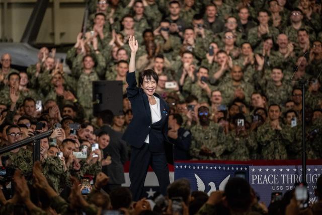 Japan's Prime Minister Sanae Takaichi gestures as she takes to the podium to speak in front of US Navy personnel during US President Donald Trump's visit to the USS George Washington aircraft carrier at the US naval base in Yokosuka on October 28, 2025. (Photo by Philip FONG / AFP)