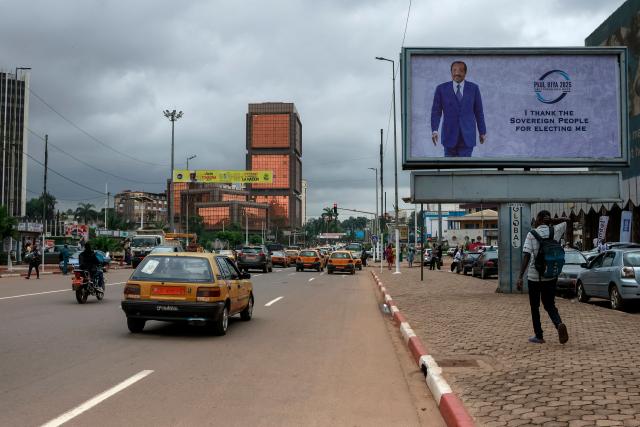 Cars drive past a billboard of Cameroon's President Paul Biya reading: "I thank the sovereign people for electing me" on a street in Yaounde, on October 28, 2025 a day after the Cameroon presidential election results were announced. Cameroon's President Paul Biya, 92, has been re-elected for an eighth term with 53.7 percent of the vote, according to official results announced by the Constitutional Council on October 27, 2025. (Photo by AFP)