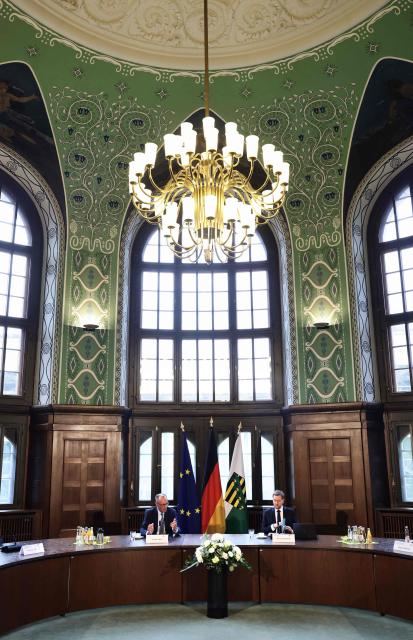 German Chancellor Friedrich Merz (L) and Saxony's State Premier Michael Kretschmer attend a cabinet meeting at Saxony's State Chancellery in Dresden, eastern Germany, on October 28, 2025, during Merz' official first visit as a Chancellor to the eastern federal state of Saxony.  (Photo by JENS SCHLUETER / AFP)
