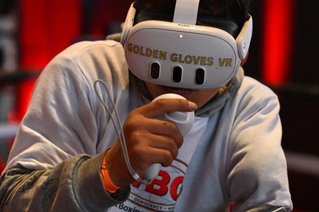 A boxing enthusiast fights with virtual reality glasses during the 38th World Boxing Organization (WBO) Annual Convention in Bogota on October 28, 2025. (Photo by Raul ARBOLEDA / AFP)