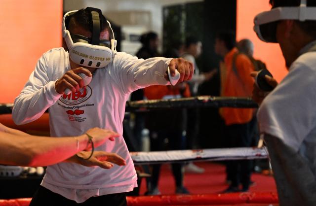 Boxing enthusiast fight with virtual reality glasses during the 38th World Boxing Organization (WBO) Annual Convention in Bogota on October 28, 2025. (Photo by Raul ARBOLEDA / AFP)