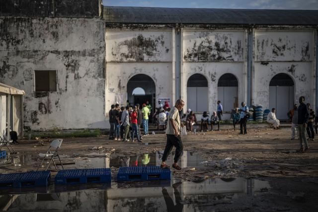 A man steps off somes raisers placed over a puddle at the Maundi polling centre in Stone Town on October 29, 2025, during Tanzania’s presidential elections. Polls opened on October 29, 2025 in Tanzania elections in which the main challengers were either jailed or barred from running, with rights groups decrying a "wave of terror".
President Samia Suluhu Hassan, 65, is determined to cement her position with an emphatic victory that will silence critics within her own party, analysts say. (Photo by MARCO LONGARI / AFP)