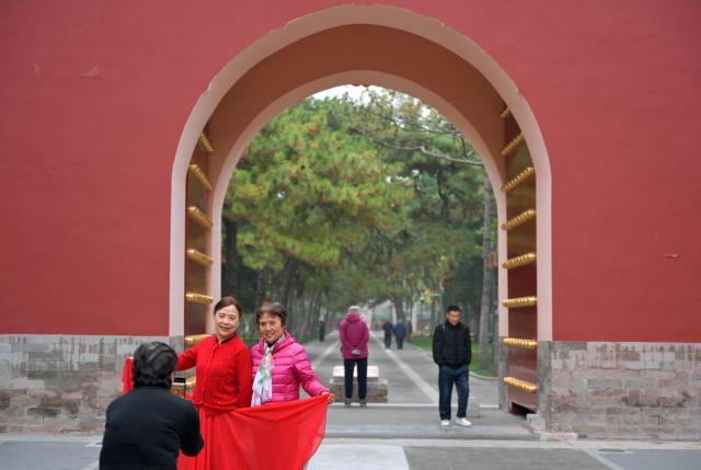 Women pose for a photo as they visit a park in Beijing on October 29, 2025. (Photo by Adek BERRY / AFP)