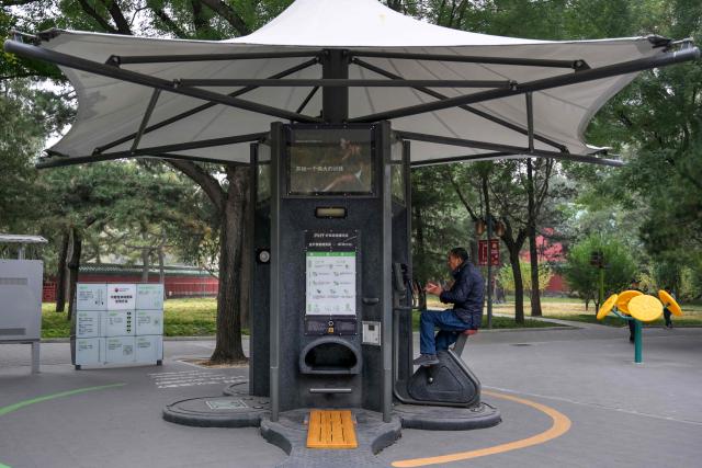 An elderly man uses a static bicycle to exercise at a park in Beijing on October 29, 2025. (Photo by Adek BERRY / AFP)