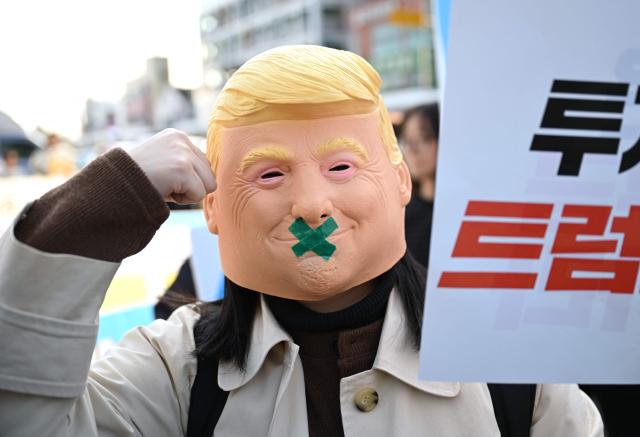 A South Korean protester wears a mask of Trump during a rally against US President Trump's visit to attend the Asia-Pacific Economic Cooperation (APEC) Summit, in Gyeongju on October 29, 2025. (Photo by Jung Yeon-je / AFP)