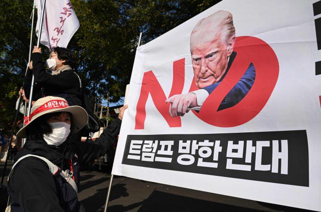 South Korean protesters hold a banner reading "No Trump" during a rally against US President Trump's visit to attend the Asia-Pacific Economic Cooperation (APEC) Summit, in Gyeongju on October 29, 2025. (Photo by Jung Yeon-je / AFP)
