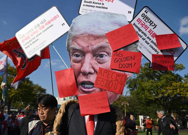 A South Korean protester wears a mask of Trump during a rally against US President Trump's visit to attend the Asia-Pacific Economic Cooperation (APEC) Summit, in Gyeongju on October 29, 2025. (Photo by Jung Yeon-je / AFP)