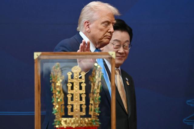 US President Donald Trump walks with South Korean President Lee Jae Myung during a high honor presentation ceremony, where Trump was presented with a replica of a crown worn by the kings of Silla, at the Gyeongju National Museum in Gyeongju on October 29, 2025. (Photo by ANDREW CABALLERO-REYNOLDS / AFP)
