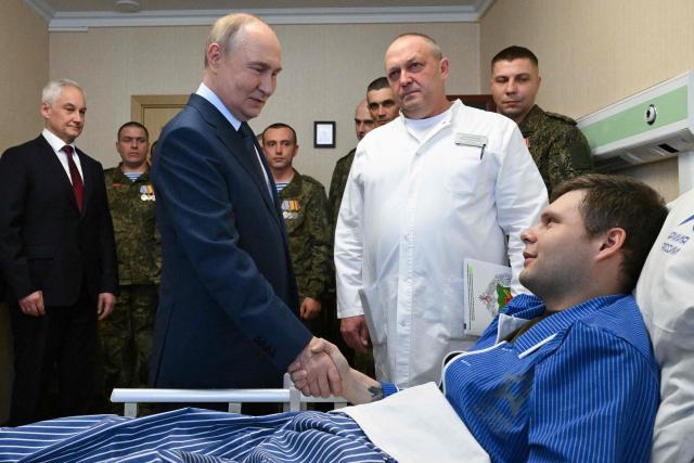 In this pool photograph distributed by the Russian state agency Sputnik, Russia's President Vladimir Putin (C) visits servicemen who were wounded during the Russian military action in Ukraine, at a military hospital in Moscow on October 29, 2025. (Photo by Kristina Kormilitsyna / POOL / AFP)