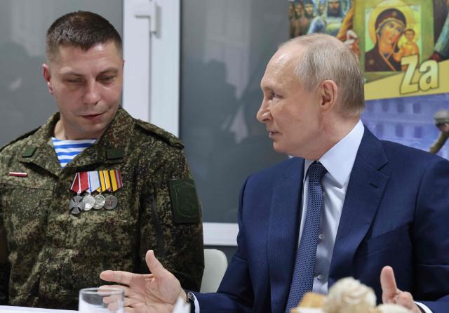 In this pool photograph distributed by the Russian state agency Sputnik, Russia's President Vladimir Putin (R) talks as he visits servicemen who were wounded during the Russian military action in Ukraine, at a military hospital in Moscow on October 29, 2025. (Photo by Vladimir GERDO / POOL / AFP)