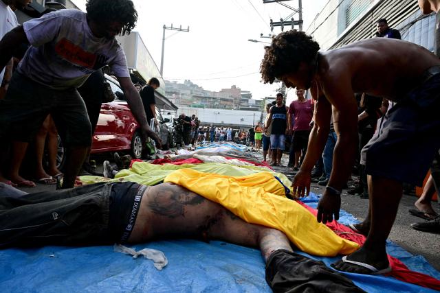 EDITORS NOTE: Graphic content / People line up bodies on Sao Lucas Square of the Vila Cruzeiro favela at the Penha complex in Rio de Janeiro, Brazil, on October 29, 2025, in the aftermath of Operacao Contencao (Operation Containment). Residents of a favela in Rio de Janeiro lined up more than 50 bodies at a plaza in their low-income neighborhood on Ocotber 29, a day after the bloodiest police operation in the city's history, AFP reported. (Photo by Pablo PORCIUNCULA / AFP)