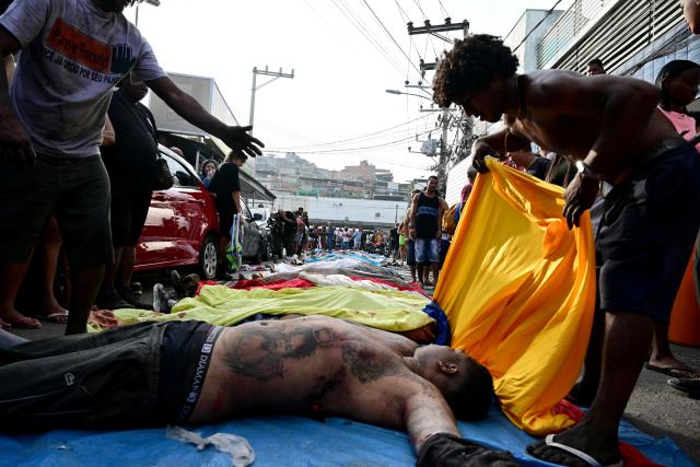 EDITORS NOTE: Graphic content / People line up bodies on Sao Lucas Square of the Vila Cruzeiro favela at the Penha complex in Rio de Janeiro, Brazil, on October 29, 2025, in the aftermath of Operacao Contencao (Operation Containment). Residents of a favela in Rio de Janeiro lined up more than 50 bodies at a plaza in their low-income neighborhood on Ocotber 29, a day after the bloodiest police operation in the city's history, AFP reported. (Photo by Pablo PORCIUNCULA / AFP)