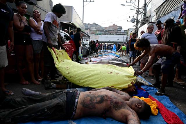 EDITORS NOTE: Graphic content / People line up bodies on Sao Lucas Square of the Vila Cruzeiro favela at the Penha complex in Rio de Janeiro, Brazil, on October 29, 2025, in the aftermath of Operacao Contencao (Operation Containment). Residents of a favela in Rio de Janeiro lined up more than 50 bodies at a plaza in their low-income neighborhood on Ocotber 29, a day after the bloodiest police operation in the city's history, AFP reported. (Photo by Pablo PORCIUNCULA / AFP)