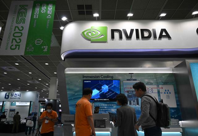 (FILES) Visitors walk past the logo of NVIDIA during the Korea Electronics Show 2025 at the COEX convention and exhibition centre in Seoul on October 22, 2025. AI chip juggernaut Nvidia became the world's first $5 trillion company on October 29, 2025, as investors remain confident that artificial intelligence will deliver a new wave of innovation and growth. The California-based tech giant saw its share price rise by 4.91 percent to $210.90 at the open of trading on Wall Street, pushing Nvidia's market capitalization past the never-before-seen threshold. (Photo by Jung Yeon-je / AFP)
