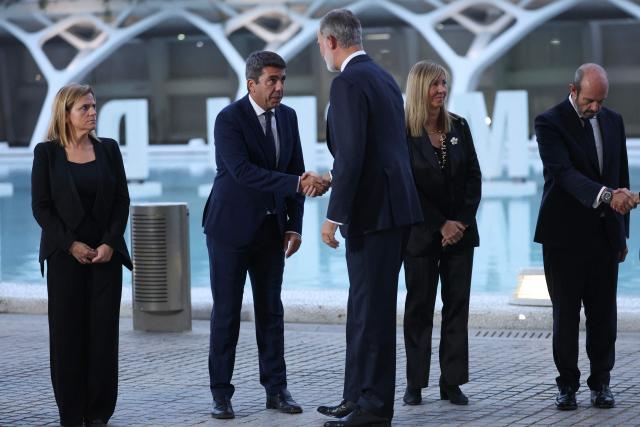 Spain's King Felipe VI (C) greets Valencia's regional president Carlos Mazon before a state memorial for the more than 230 victims of last year's floods on the one year anniversary of the disaster at the City of Arts and Sciences cultural and architectural complex in Valencia on October 29, 2025. The regional government has declared a day of mourning, while the town of Paiporta, at the epicentre of the disaster, will observe three days of remembrance. (Photo by Oscar DEL POZO / AFP)