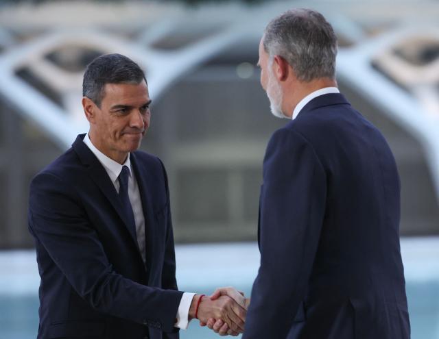Spain's King Felipe VI (R) greets Spain's Prime Minister Pedro Sanchez before a state memorial for the more than 230 victims of last year's floods on the one year anniversary of the disaster at the City of Arts and Sciences cultural and architectural complex in Valencia on October 29, 2025. The regional government has declared a day of mourning, while the town of Paiporta, at the epicentre of the disaster, will observe three days of remembrance. (Photo by Oscar DEL POZO / AFP)