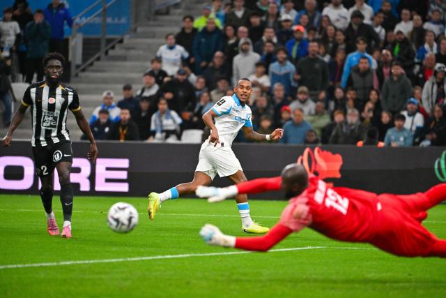 Angers' Burkinabe goalkeeper #12 Herve Koffi (R) stops a shot from Marseille's Brazilian forward #14 Igor Paixao (C) during the French L1 football match between Olympique de Marseille (OM) and SCO Angers at the Velodrome stadium in Marseille, southern France, on October 29, 2025. (Photo by Christophe SIMON / AFP)