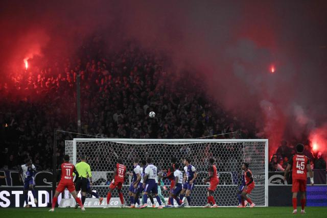 Supporters hold lit flares  during the French L1 football match between Toulouse FC and Stade Rennais FC at the Stadium in Toulouse, southwestern France, on October 29, 2025. (Photo by Ed JONES / AFP)