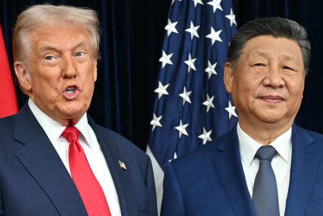 US President Donald Trump (L) and China's President Xi Jinping greet each other as they arrive for talks at the Gimhae Air Base, located next to the Gimhae International Airport in Busan on October 30, 2025. Donald Trump and Chinese leader Xi Jinping will seek a truce in their bruising trade war on October 30, with the US president predicting a "great meeting" but Beijing being more circumspect. (Photo by ANDREW CABALLERO-REYNOLDS / AFP)