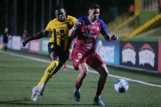 Real Espana's defender #21 Danilo Palacios and Xelaju's Paraguayan forward #09 Pedro Baez fight for the ball during the second leg of the CONCACAF Central American Cup semifinal football match between Guatemala's Xelaju and Honduras's Real Espana at Cementos Progreso Stadium in Guatemala City on October 29, 2025. (Photo by Edwin Bercian / AFP)