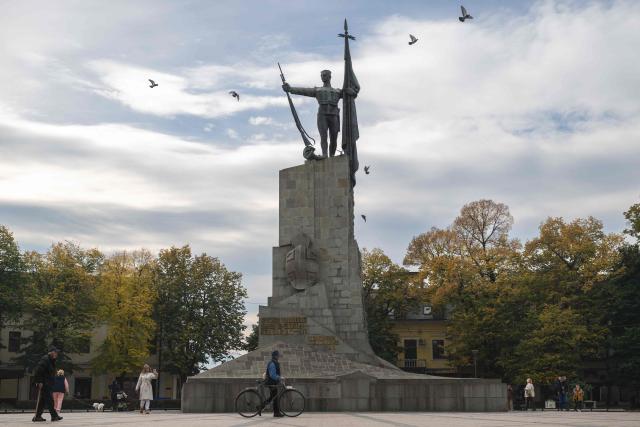 People walk past a WWI monument at the main square in the city of Kraljevo, Central Serbia, on October 21, 2025. Serbia is preparing to mark the first anniversary of the Novi Sad tragedy, which sparked some of the biggest protests in its history — a year that left the country deeply changed and polarised.
The train-station collapse in the country’s second-largest city, which killed 16 people just months after renovation, became a symbol of entrenched corruption — bringing hundreds of thousands to the streets under the "bloody hand" stencil that became its emblem. (Photo by Andrej ISAKOVIC / AFP)