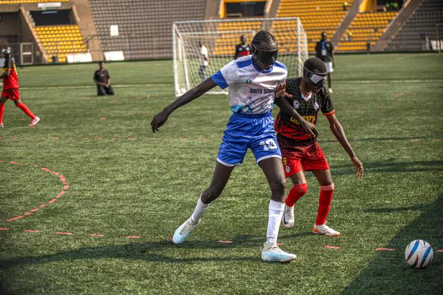 Players from South Sudan and Ugandas blind football team fight for the ball during a match at Hamz Stadium Nakivubo War Memorial Grounds in Kampala, on October 27, 2025. South Sudan's national blind football team, the Bright Stars, is making its international debut in a mini-tournament in Kampala, featuring teams from Uganda and Zimbabwe. The tournament offers the team greater visibility and a chance to compete for a spot at the 2028 Paralympics in California. South Sudan's team began humbly five years ago with just two players under the guidance of sighted head coach Simon Madol Akol, who has since grown the team to 40 members. (Photo by Stuart Tibaweswa / AFP)