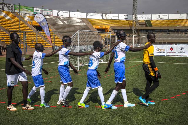 Players from South Sudans blind football team make their way to the pitch to play the second half of a match against Uganda at Hamz Stadium Nakivubo War Memorial Grounds in Kampala, on October 27, 2025. South Sudan's national blind football team, the Bright Stars, is making its international debut in a mini-tournament in Kampala, featuring teams from Uganda and Zimbabwe. The tournament offers the team greater visibility and a chance to compete for a spot at the 2028 Paralympics in California. South Sudan's team began humbly five years ago with just two players under the guidance of sighted head coach Simon Madol Akol, who has since grown the team to 40 members. (Photo by Stuart Tibaweswa / AFP)