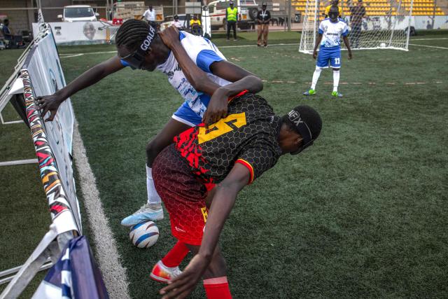 Players from South Sudan and Ugandas blind football team fight for the ball during a match at Hamz Stadium Nakivubo War Memorial Grounds in Kampala, on October 27, 2025. South Sudan's national blind football team, the Bright Stars, is making its international debut in a mini-tournament in Kampala, featuring teams from Uganda and Zimbabwe. The tournament offers the team greater visibility and a chance to compete for a spot at the 2028 Paralympics in California. South Sudan's team began humbly five years ago with just two players under the guidance of sighted head coach Simon Madol Akol, who has since grown the team to 40 members. (Photo by Stuart Tibaweswa / AFP)