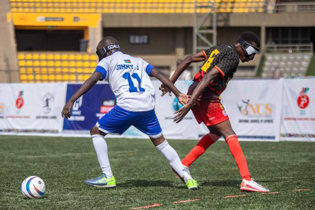 Players from South Sudan and Ugandas blind football team fight for the ball during a match at Hamz Stadium Nakivubo War Memorial Grounds in Kampala, on October 27, 2025. South Sudan's national blind football team, the Bright Stars, is making its international debut in a mini-tournament in Kampala, featuring teams from Uganda and Zimbabwe. The tournament offers the team greater visibility and a chance to compete for a spot at the 2028 Paralympics in California. South Sudan's team began humbly five years ago with just two players under the guidance of sighted head coach Simon Madol Akol, who has since grown the team to 40 members. (Photo by Stuart Tibaweswa / AFP)