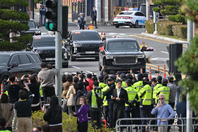 A motorcade of China's President Xi Jinping leaves an air base at Gimhae International Airport in Busan on October 30, 2025, as he arrives to attend the Asia-Pacific Economic Cooperation (APEC) Summit. (Photo by Jung Yeon-je / AFP)