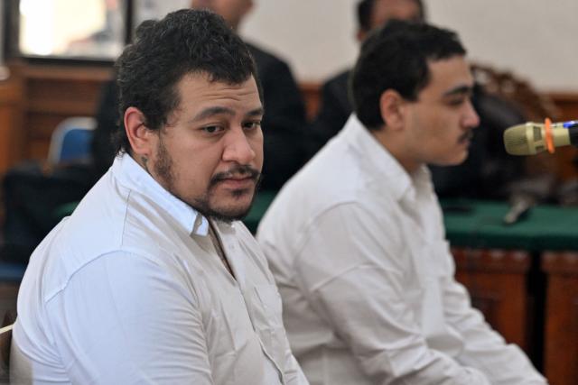 Australian suspect Tupou Pasa Midolmore (L) and Australian suspect Mevlut Coskun attend a hearing as part of a trial at a court in Denpasar on Indonesia's resort island of Bali on October 30, 2025. Midolmore and Coskun were arrested along with another suspect in connection with the June 14 shooting at a villa in Munggu, Badung, Bali, which left one dead and another critically injured. (Photo by SONNY TUMBELAKA / AFP)