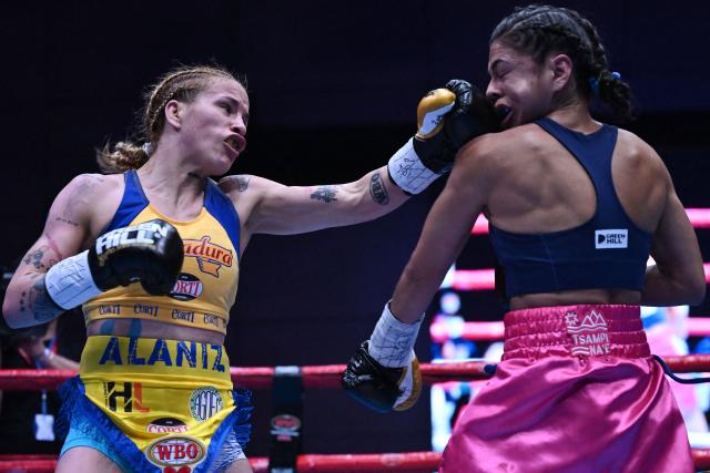 Argentina's Gabriela Celeste Alaniz throws a left punch at Colombia's Laura Wollenmann during their Championship flyweight title bout (112 lbs) at the 38th WBO Annual Convention, Night of Champions, at the Agora multiformat events center in Bogota on October 29, 2025. (Photo by Raul ARBOLEDA / AFP)