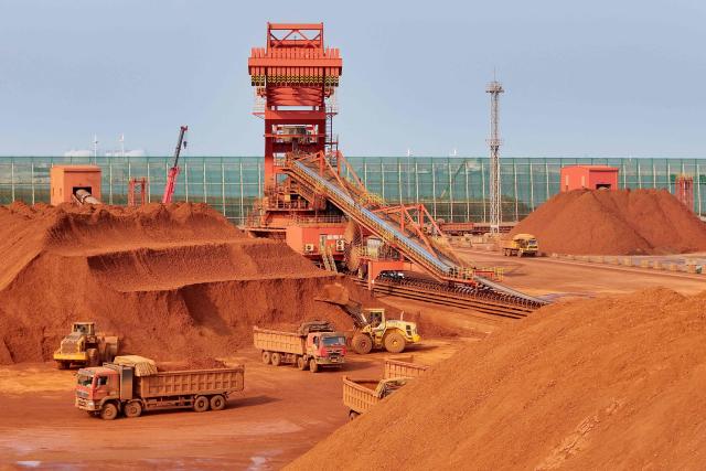 Heavy machinery handling bauxite ore is seen at the Yantai port in eastern China's Shandong province on October 29, 2025. (Photo by AFP) / China OUT