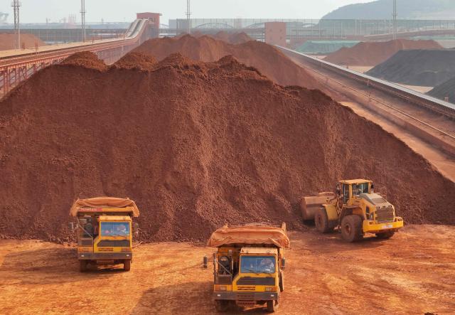 Heavy machinery handling bauxite and iron ore is seen at the Yantai port in eastern China's Shandong province on October 29, 2025. (Photo by AFP) / China OUT