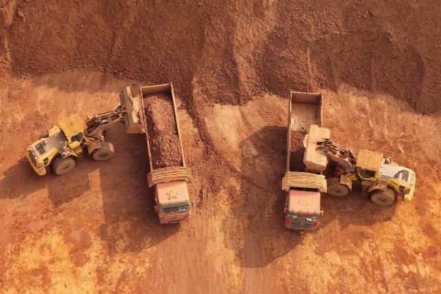 Heavy machinery handling bauxite ore is seen at the Yantai port in eastern China's Shandong province on October 29, 2025. (Photo by AFP) / China OUT