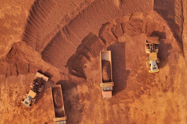 Heavy machinery handling bauxite ore is seen at the Yantai port in eastern China's Shandong province on October 29, 2025. (Photo by AFP) / China OUT
