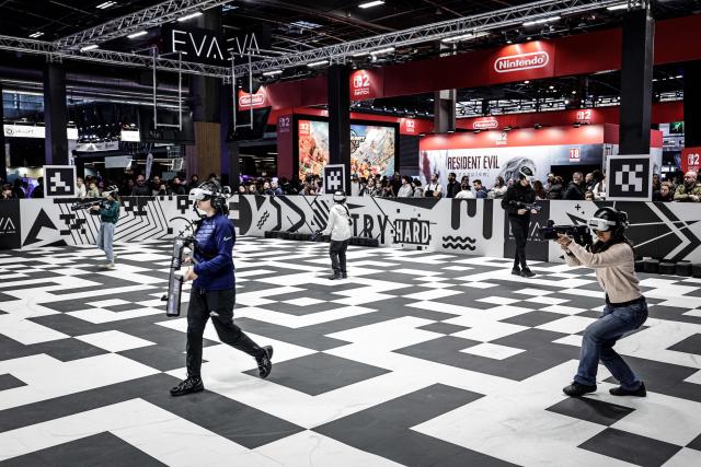 Visitors play a VR game at the EVA area during the Paris Games Week fair in Paris, on October 30, 2025. Supported by new partners, the 14th edition of the largest video game fair in France is making its return until November 2, 2025 at the Porte de Versailles in Paris, in a format even more focused on shows and pop culture. (Photo by STEPHANE DE SAKUTIN / AFP)