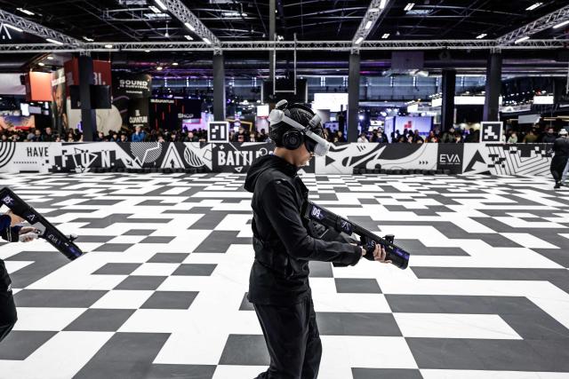 Visitors play a VR game at the EVA area during the Paris Games Week fair in Paris, on October 30, 2025. Supported by new partners, the 14th edition of the largest video game fair in France is making its return until November 2, 2025 at the Porte de Versailles in Paris, in a format even more focused on shows and pop culture. (Photo by STEPHANE DE SAKUTIN / AFP)